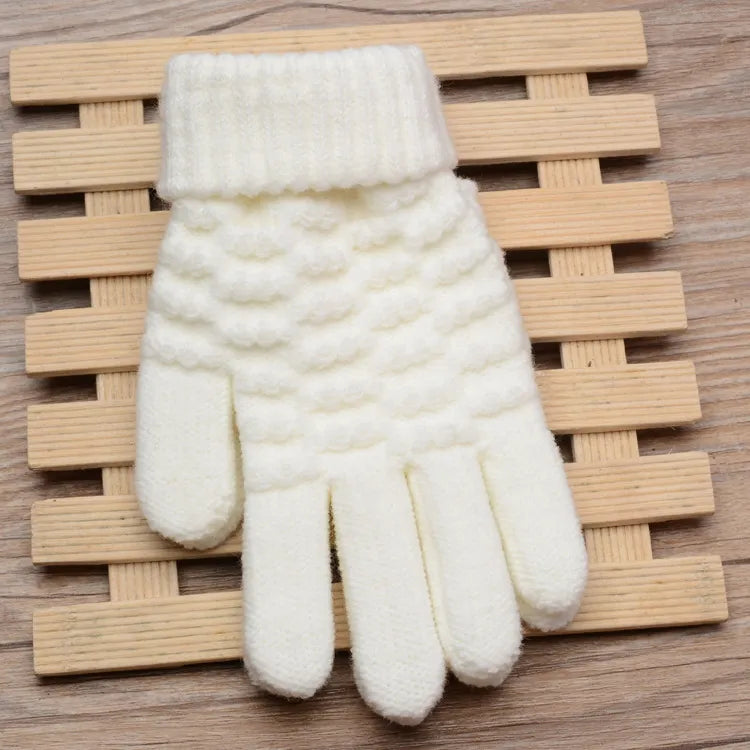 Weiße gestrickte Wollhandschuhe auf Holzunterlage, Wintermode Accessoire, warm und stilvoll.