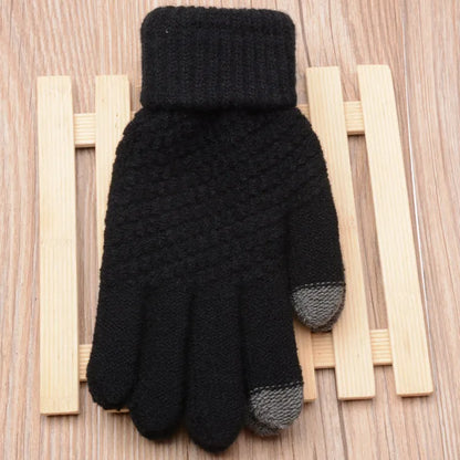 Schwarzer Strickhandschuh mit grauen Fingerspitzen auf Holzuntergrund, Wintermode Accessoire.