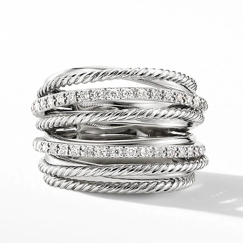 Silberring mit mehreren verdrehten Bändern und funkelnden Kristallen, elegantes Schmuckdesign.