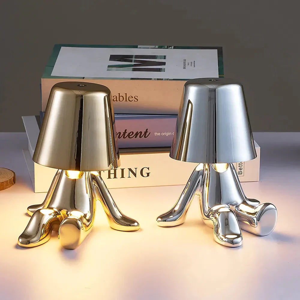 Zwei moderne Tischlampen in Gold und Silber, Buchstapel, stilvolle Beleuchtung, Wohnzimmer-Dekor.