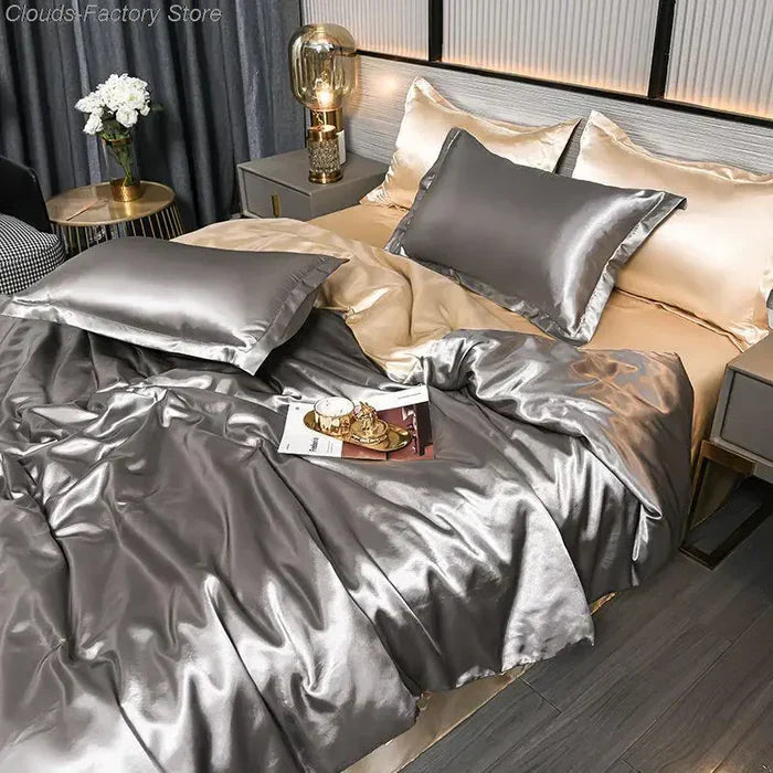 Luxuriöse silberne Satin-Bettwäsche-Set mit Kissen und Decke im modernen Schlafzimmer.