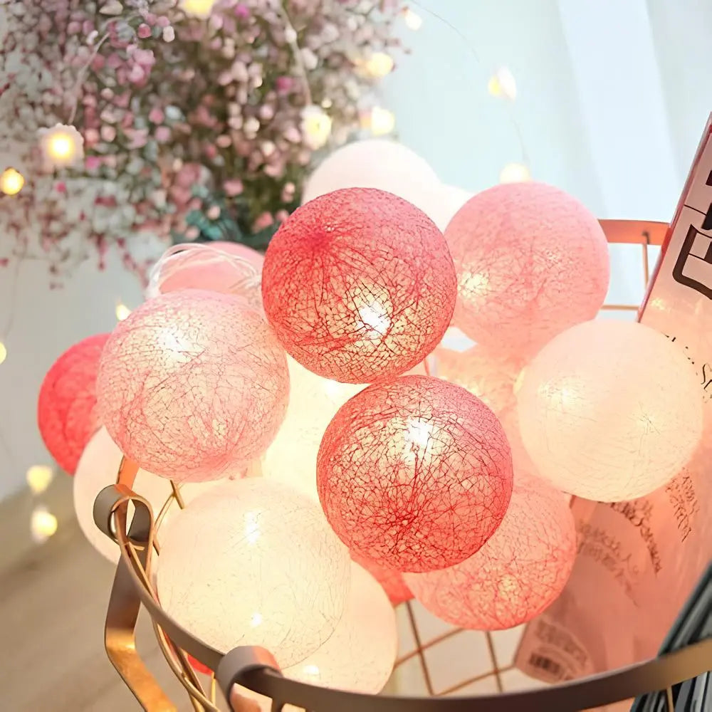 Rosa und weiße LED-Lichterkette in einem goldenen Korb, dekorative Beleuchtung.