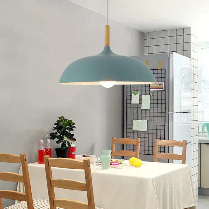 Blaue Pendelleuchte aus Metall über Esstisch, skandinavisches Design, moderne Innenbeleuchtung.