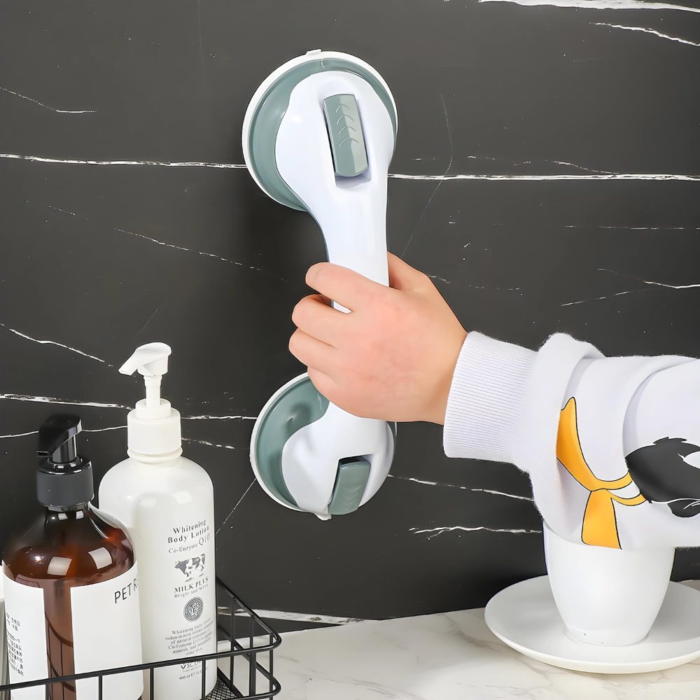 Hand hält weißen Duschgriff mit Saugnäpfen an schwarzer Fliesenwand im Badezimmer.