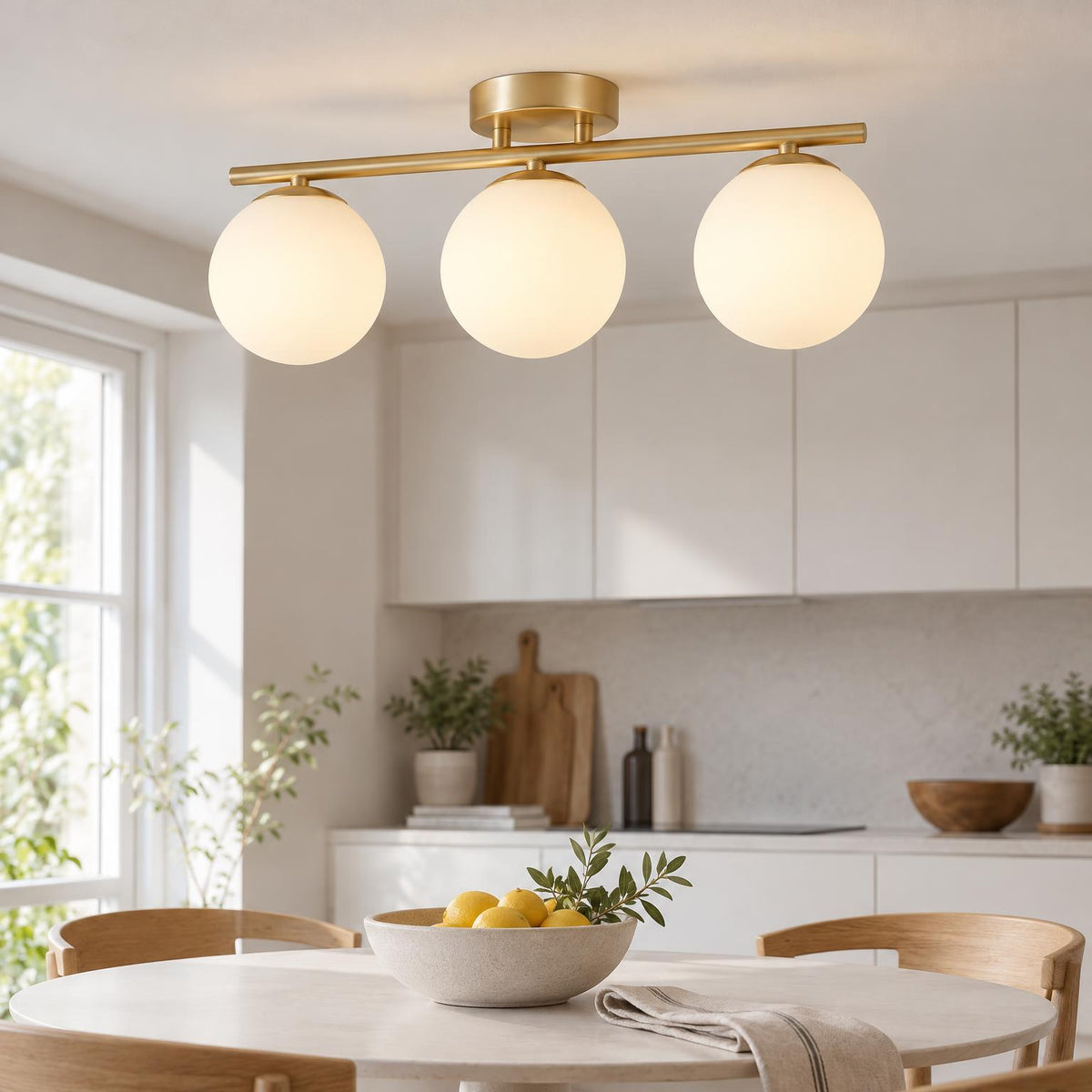Lampa med tre glaskulor på mässingsfärgad skena sedd snett underifrån i modernt kök 4
