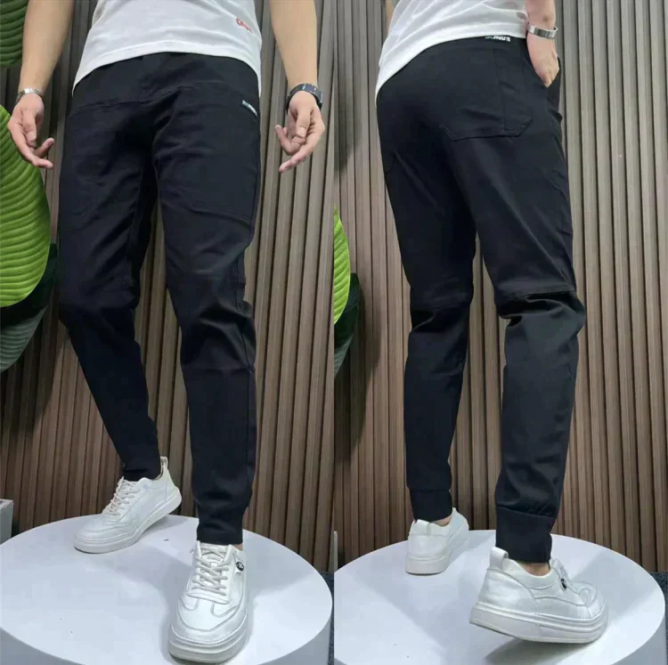 Schwarze Jogginghose Herren, Slim Fit, Baumwolle, sportlich, bequem, mit weißen Sneakers.