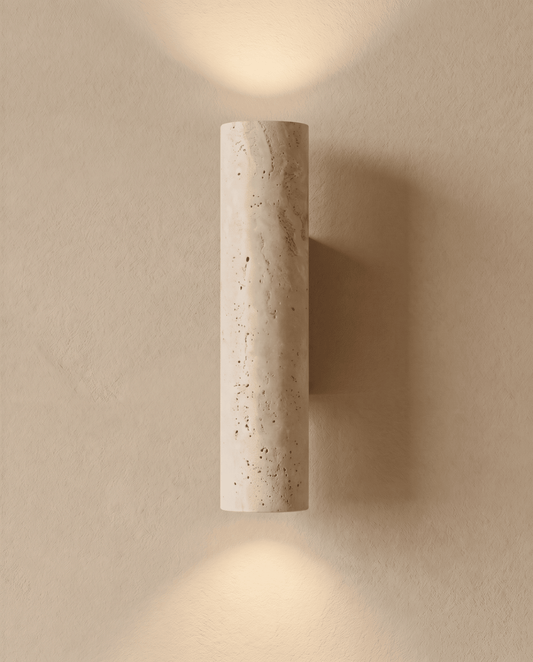Tänd travertinlampa sedd rakt framifrån, ljuset sprids uppåt och nedåt över den beige väggen 2