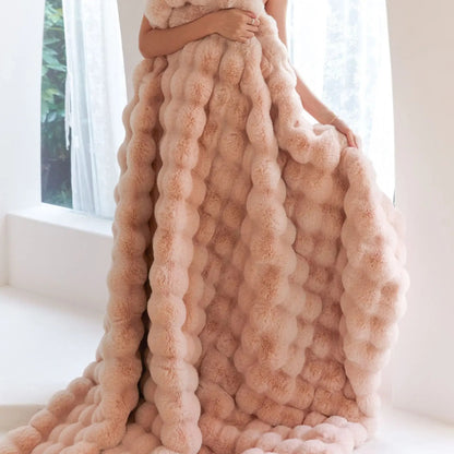 Flauschige rosa Decke, voluminös, luxuriös, weiches Material, ideal für gemütliche Wohnräume.