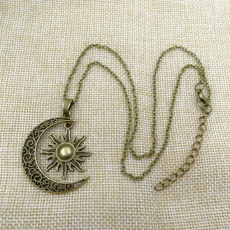 Antike bronzene Sonnen- und Mondkette auf Jutestoff, Vintage-Schmuck, Boho-Stil.