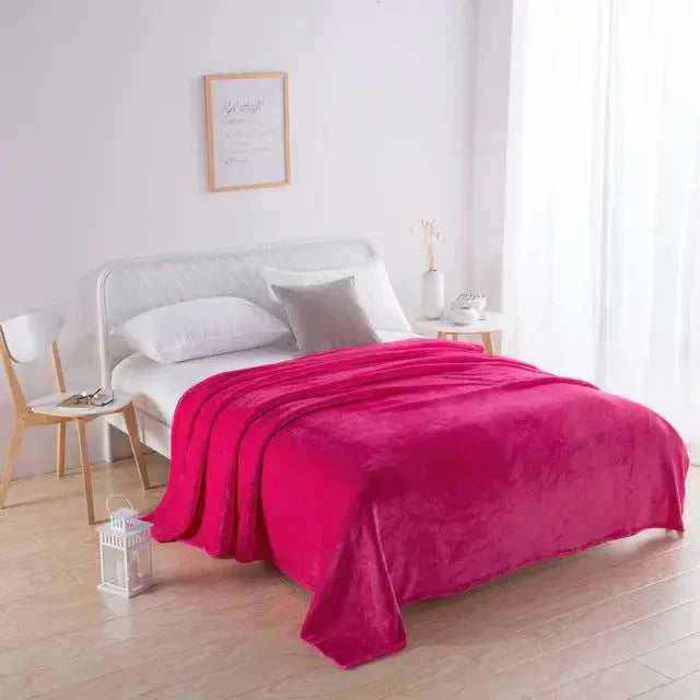 Rotes Plüschbettdecke auf weißem Bett in modernem Schlafzimmer, gemütliche Inneneinrichtung.