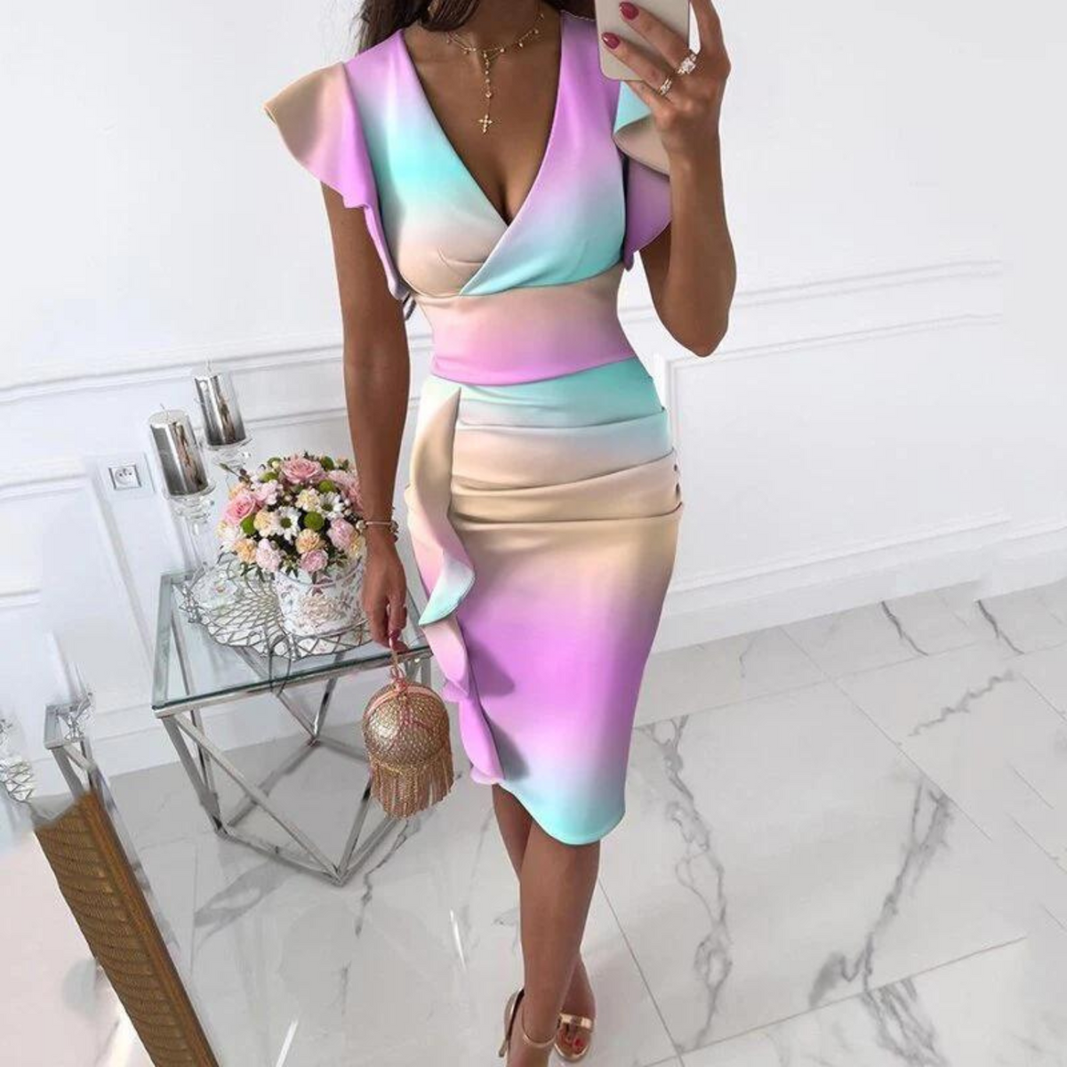 Frau in pastellfarbenem Kleid mit Rüschen, V-Ausschnitt, Blumenstrauß im Hintergrund.