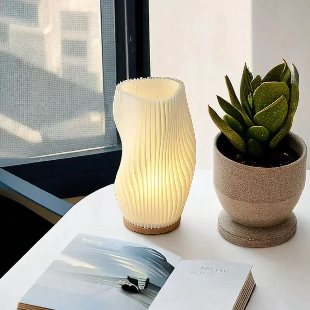 Moderne Tischlampe aus Holz und Papier neben Sukkulente auf Tisch, skandinavisches Design.