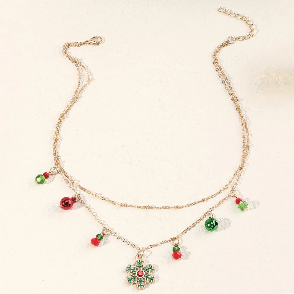 Goldene Halskette mit Weihnachtsanhänger, Schneeflocke, rote und grüne Perlen, festlicher Schmuck.