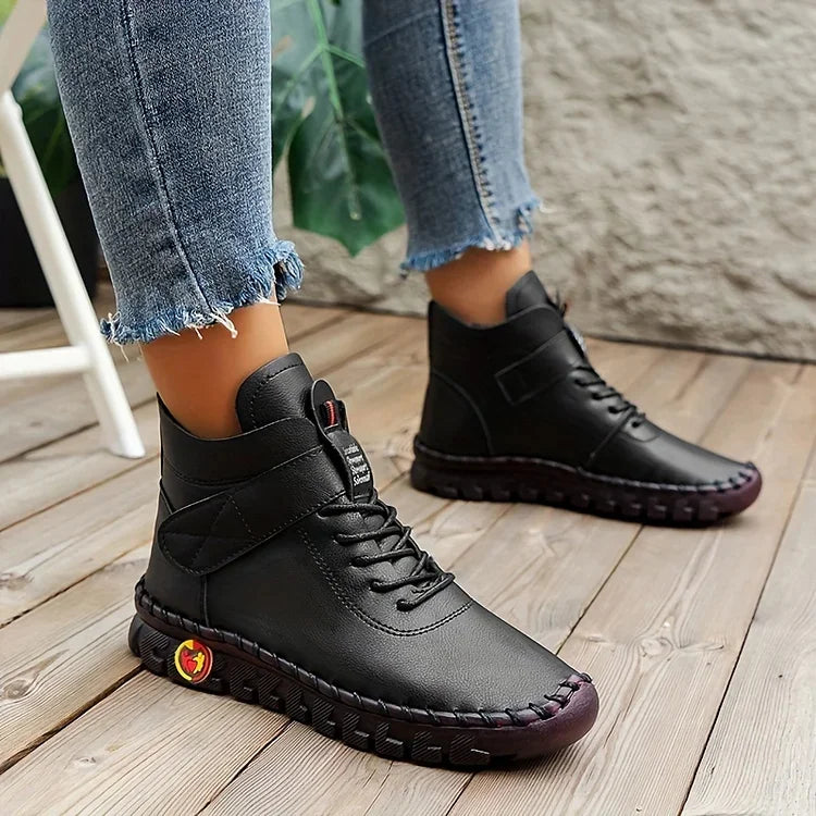 Schwarze Lederstiefel für Damen, lässig, mit Schnürung, auf Holzboden, modisch, bequem.