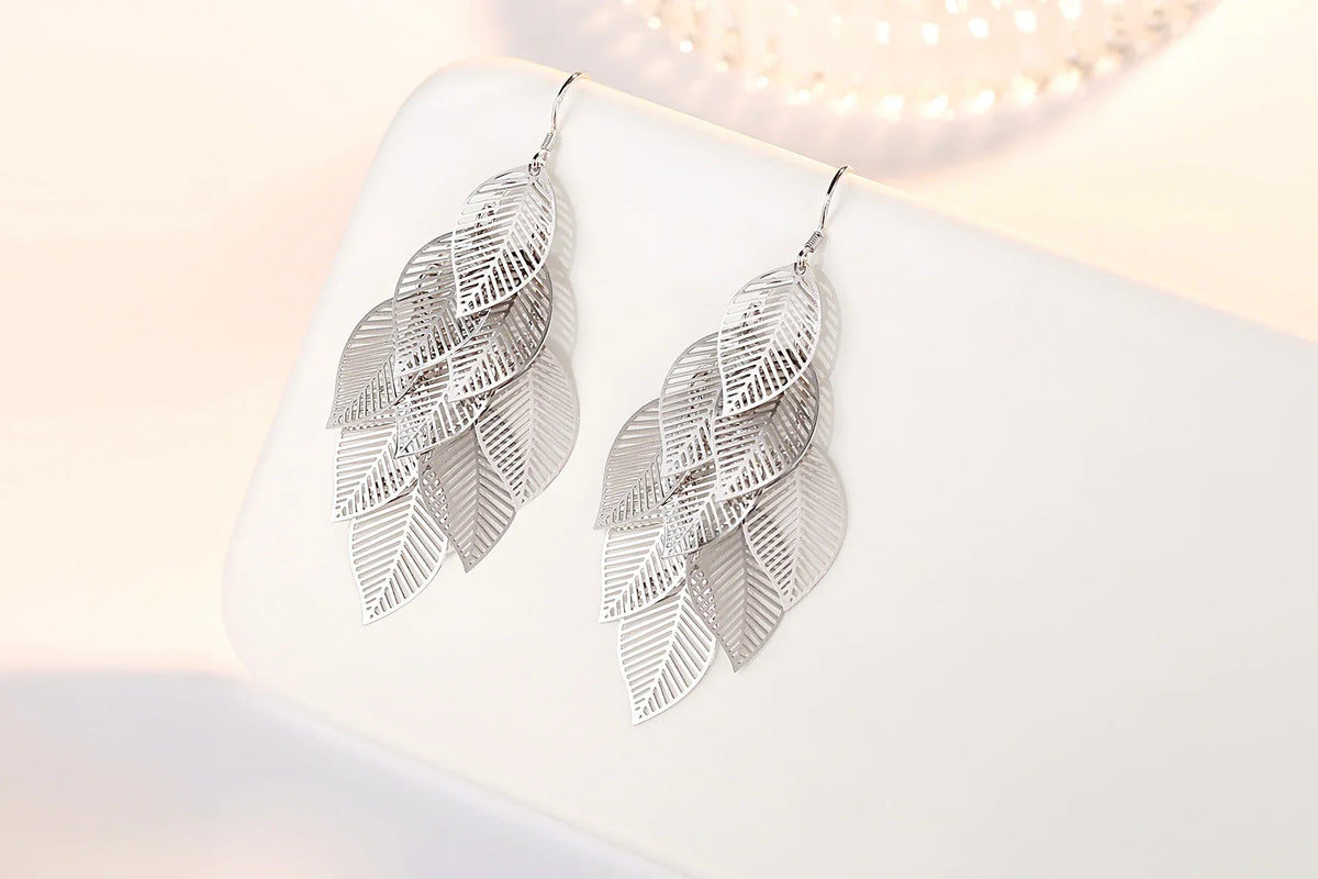 Silberne Ohrringe mit filigranem Blattdesign, eleganter Schmuck für Damen.