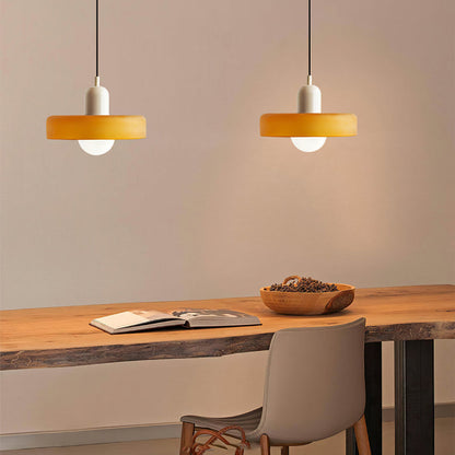 Moderne bunte Glas-Pendelleuchte über Holztisch, gelber Lampenschirm, Inneneinrichtung.