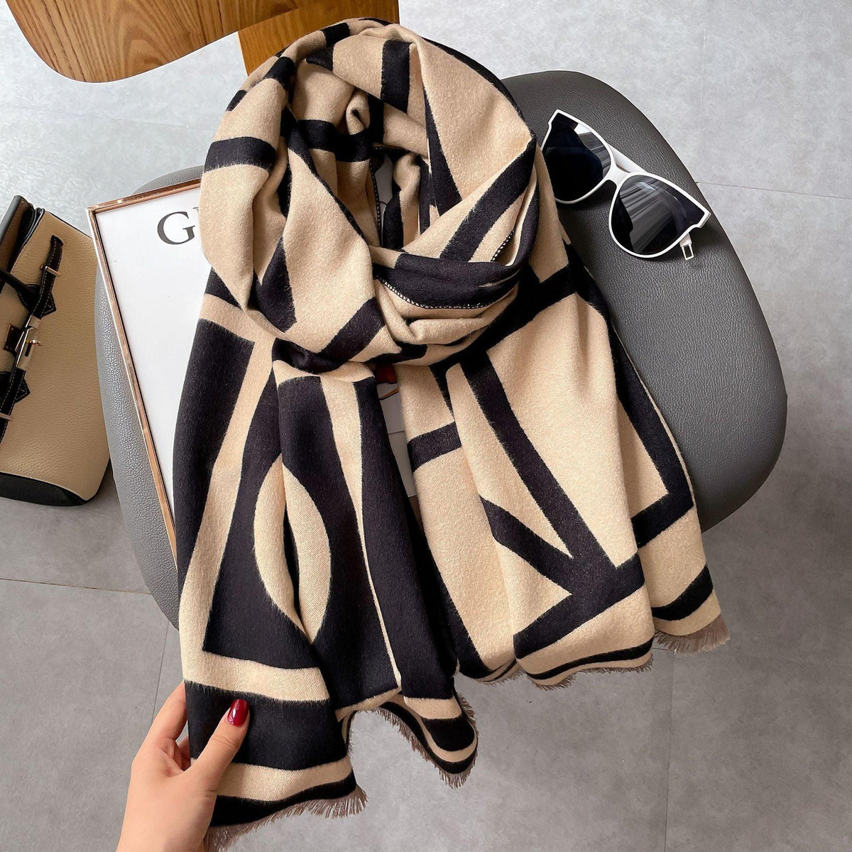 Beige-schwarzer Schal mit geometrischem Muster, Damenmode, Accessoire, Herbst-Winter-Trend.