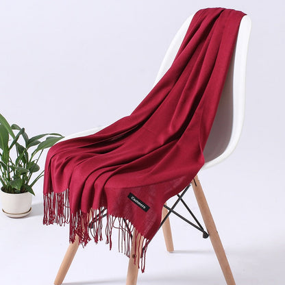 Roter Kaschmirschal auf Stuhl, weiches Material, modisches Accessoire, ideal für Herbst/Winter.