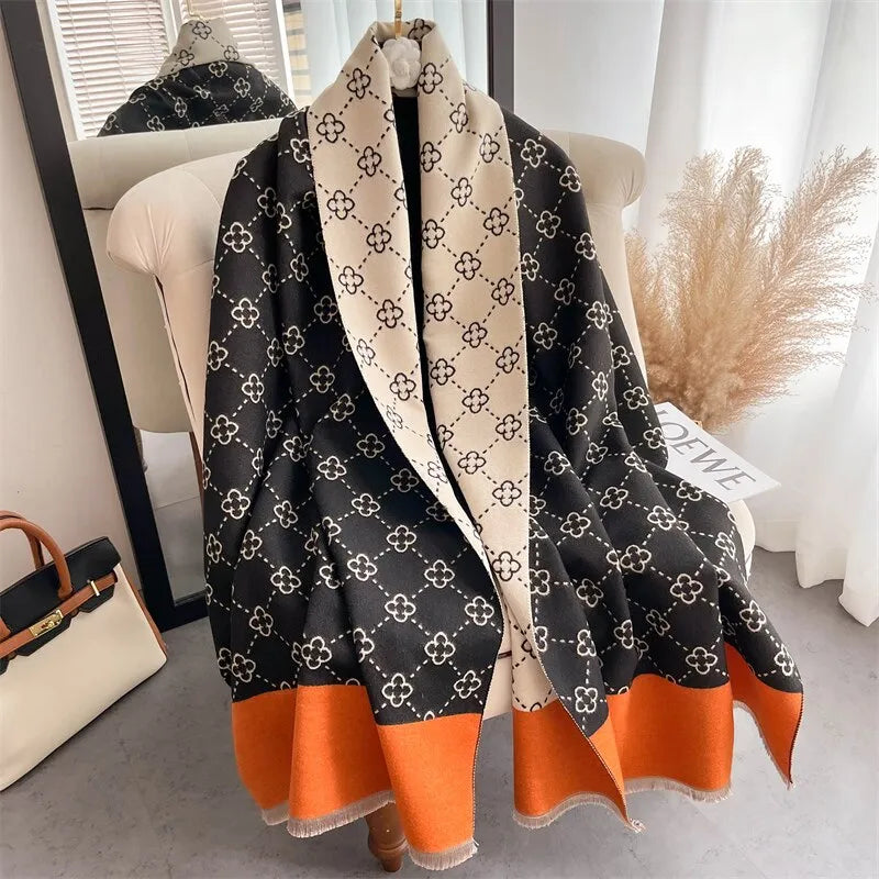Luxuriöser schwarz-weißer Designer-Schal mit orangefarbenem Rand, geometrisches Muster.