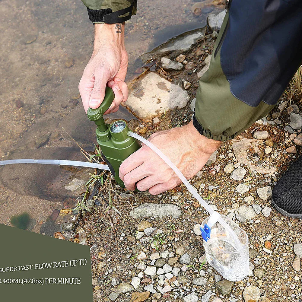 Person pumpt Wasser mit tragbarem, grünem Wasserfilter am Flussufer, Outdoor-Ausrüstung.