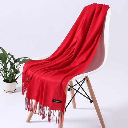 Roter Kaschmirschal auf weißem Stuhl, weiches Material, modisches Accessoire, Wohnzimmer.
