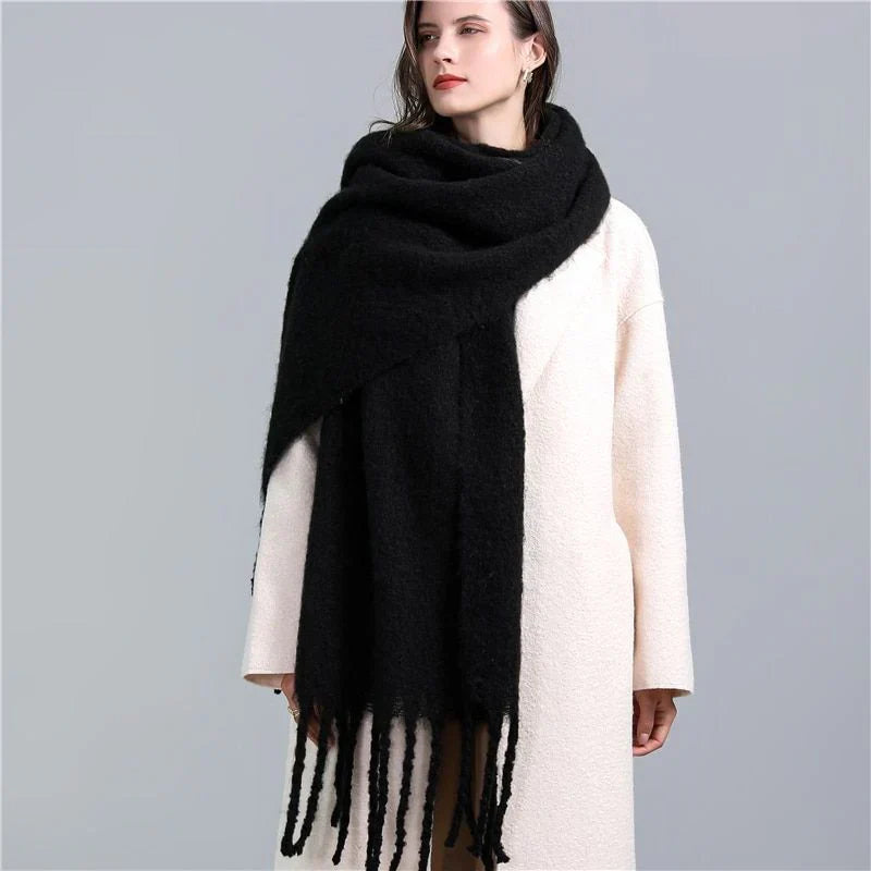Frau mit schwarzem Wollschal und weißem Mantel, modisches Winteroutfit, elegant und warm.