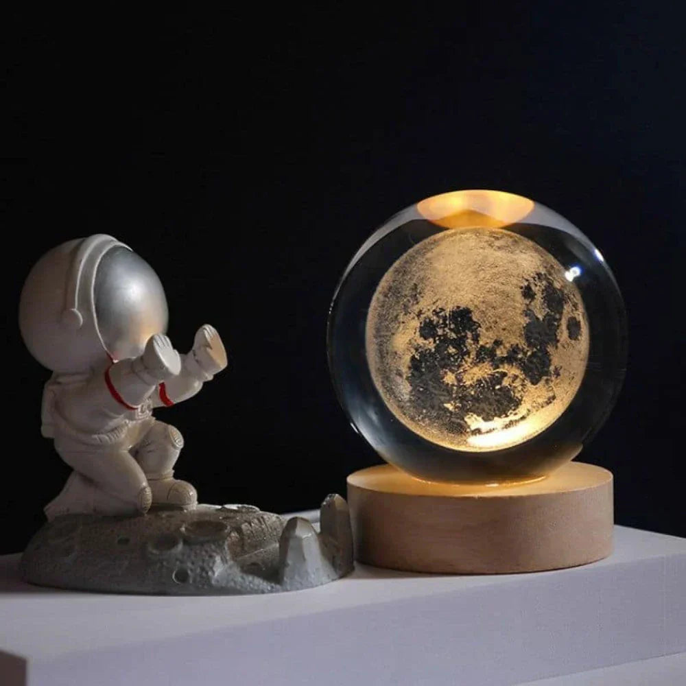 Astronautenfigur und leuchtender Mond in Glaskugel auf Holzsockel, dekorative Lampe.