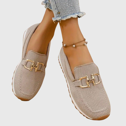 Beige loafers i mesh med guldspänne, modellens ben korsade, sedda uppifrån och framifrån 5