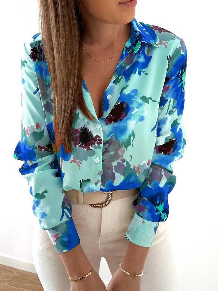 Frau in blauer Blumenbluse, lange Ärmel, V-Ausschnitt, modisch, elegant, Damenmode.