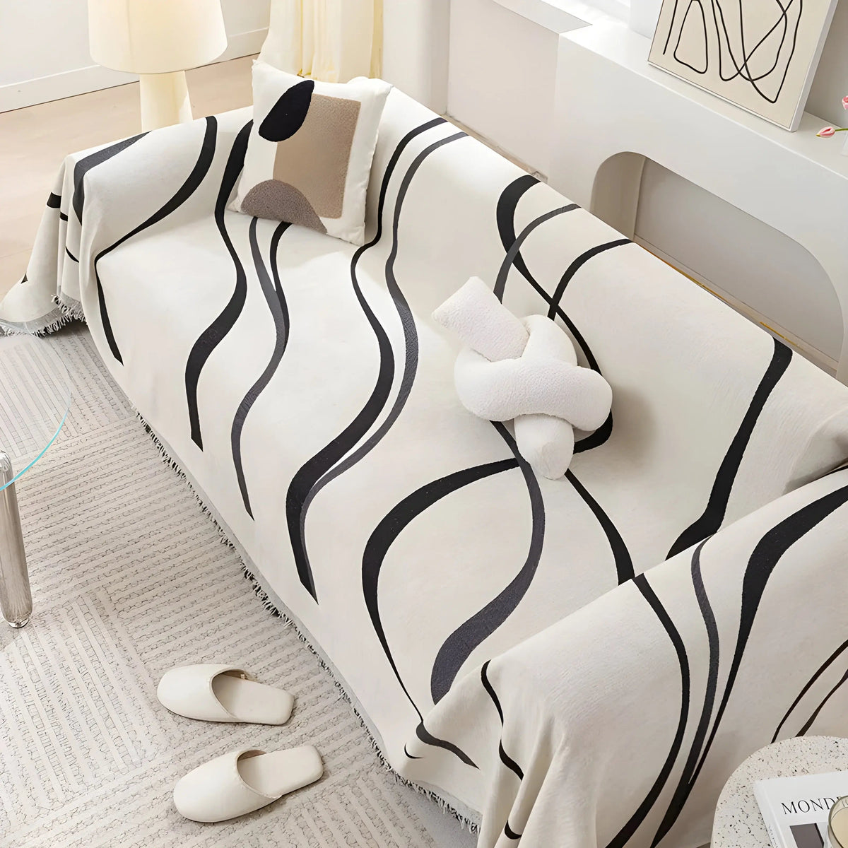 Schwarz-weiß gestreiftes Sofa mit Kissen, modernes Wohnzimmer, minimalistische Einrichtung.