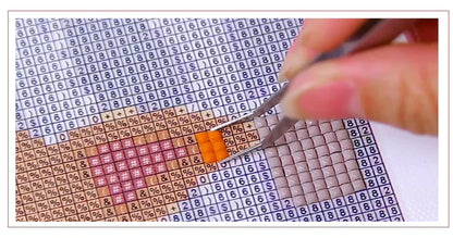 Hand legt orange Steinchen auf Diamant-Malerei Vorlage, Nahaufnahme, DIY Kunsthandwerk.