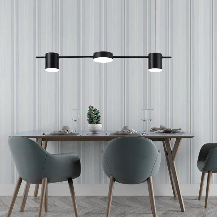 Moderne schwarze Pendelleuchte über Esstisch, graue Stühle, minimalistische Einrichtung.