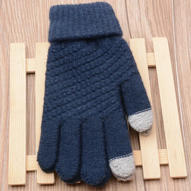 Dunkelblaue Strickhandschuhe mit grauen Fingerspitzen auf Holzuntergrund, Wintermode Accessoire.