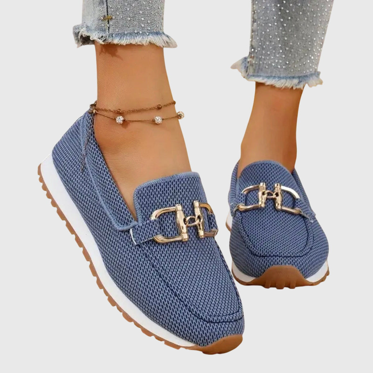 Blå mesh-loafers med guldfärgat spänne och vit sula, på modell med glittriga jeans 1