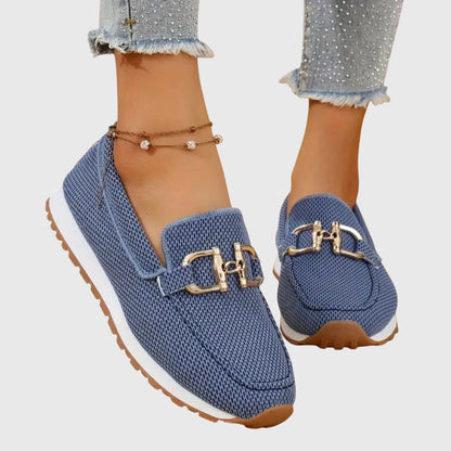 Blå mesh-loafers med guldfärgat spänne och vit sula, på modell med glittriga jeans 1