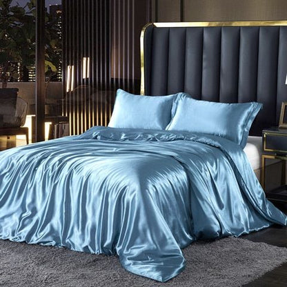 Luxuriöses blaues Seidensatin-Bettwäsche-Set auf modernem Bett mit gepolstertem Kopfteil.