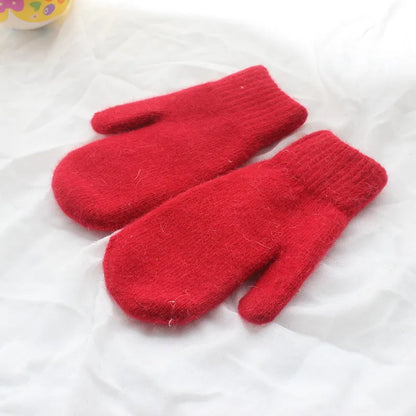 Rote Wollfäustlinge auf weißem Hintergrund, warme Winterhandschuhe, gestrickt.