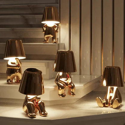 Goldene Lampen in Form von sitzenden Figuren auf Treppe, modernes Design, Innenbeleuchtung.